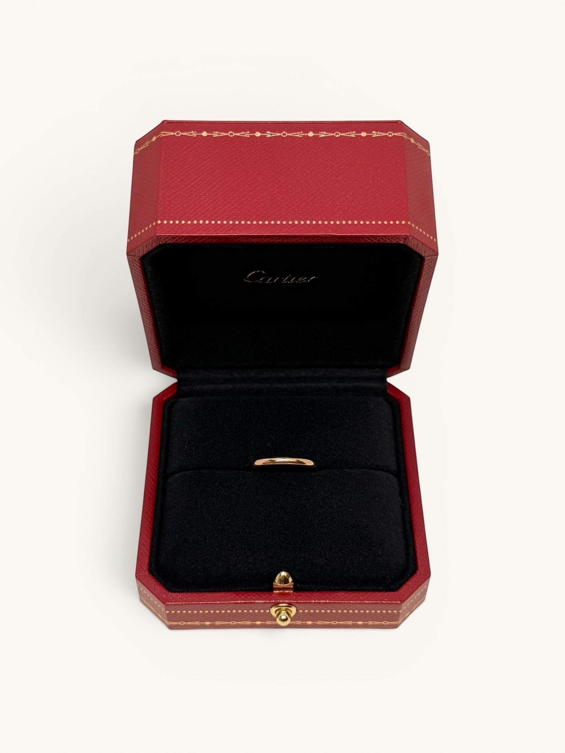 By the Hour Cartier 1895 wedding band in pink gold, 2.5mm wide, presented in a red Cartier ring box.
