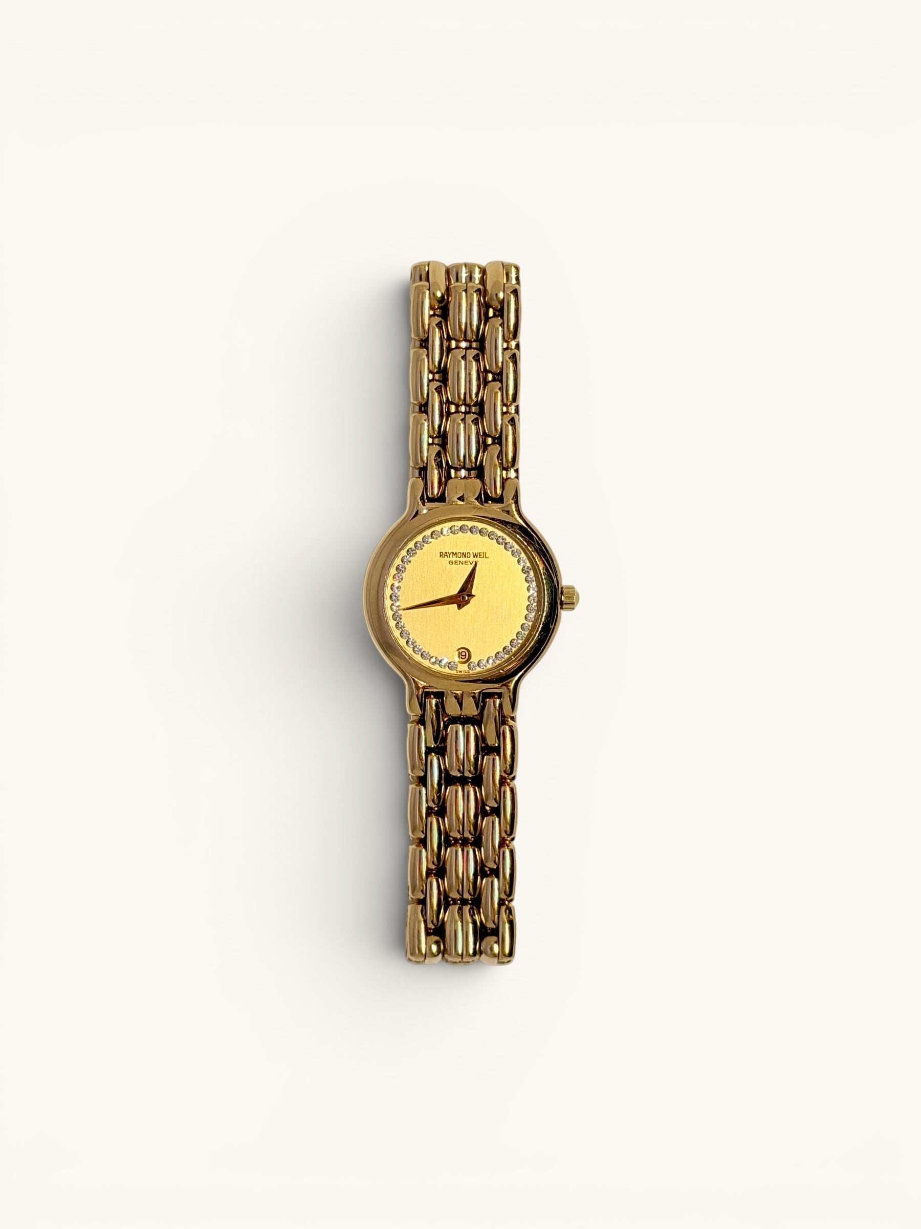 By the Hour vintage gold-tone Raymond Weil Fidelio watch with diamond dial and date window at 6 o'clock. Features a linked bracelet and Swiss quartz movement.