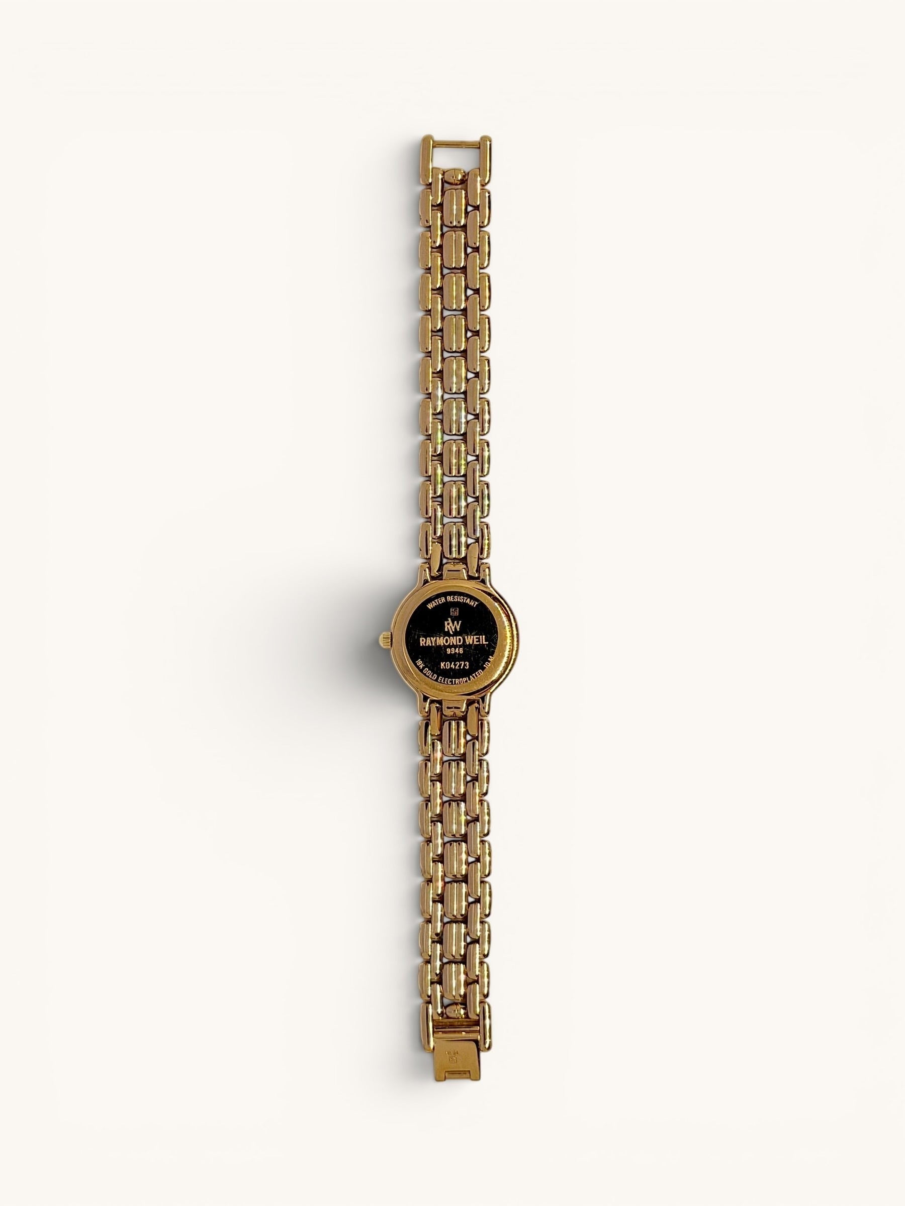 By the Hour vintage Raymond Weil Fidelio 9946 watch with gold-tone case, linked bracelet, diamond dial, and date window.